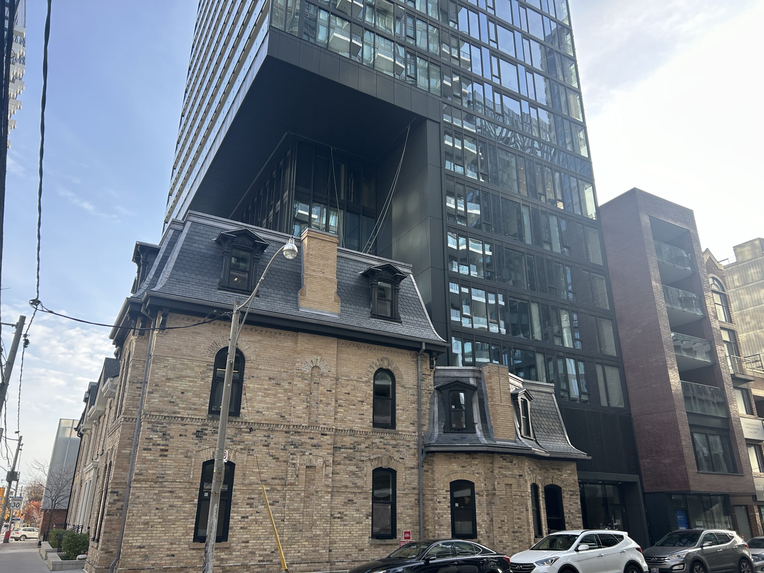 An old building in Toronto with a large condo built on top of it