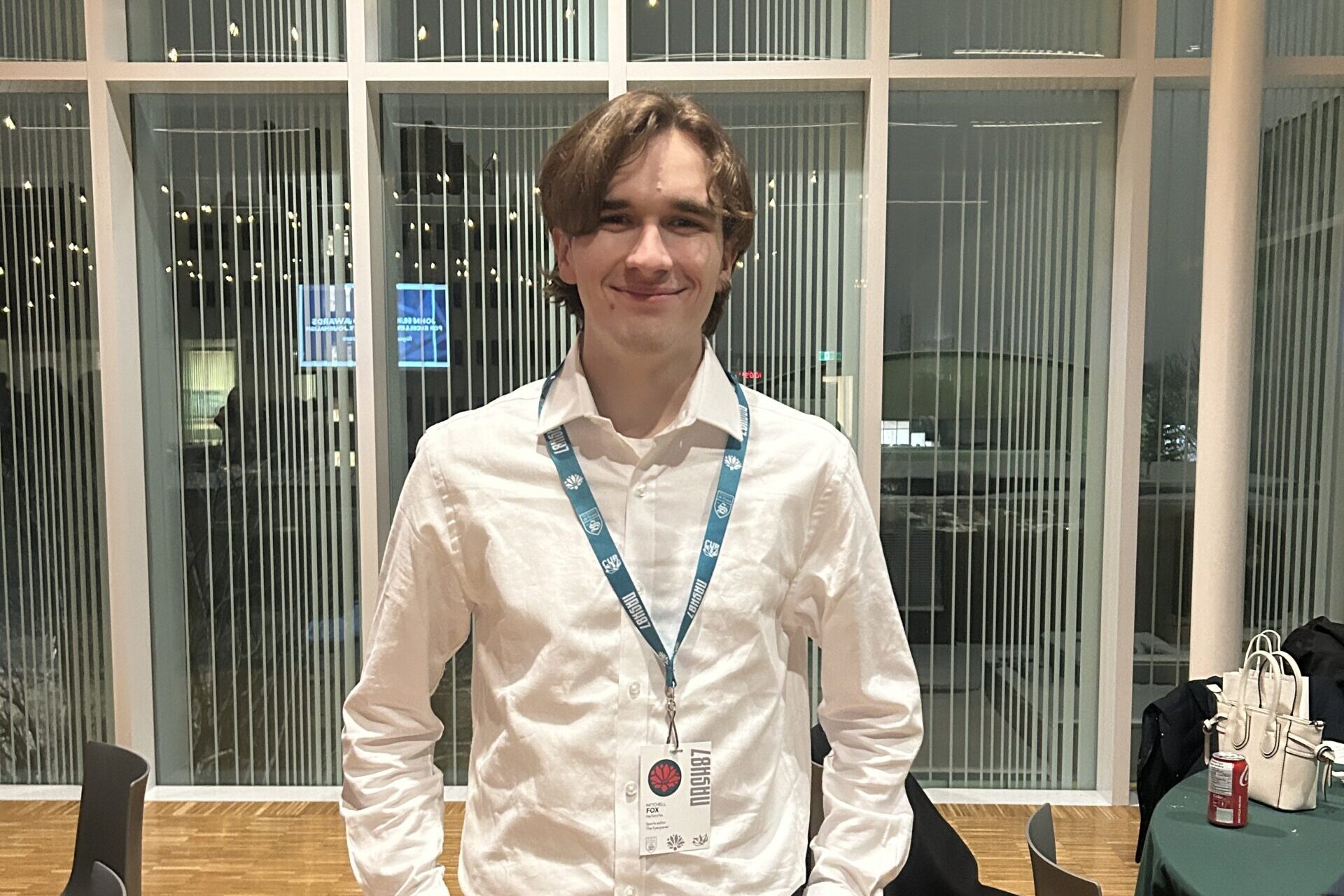 Mitchell Fox wearing a white button-up shirt and a nametag for NASH